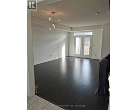 A spacious room with a chandelier and a view of a doorway.
