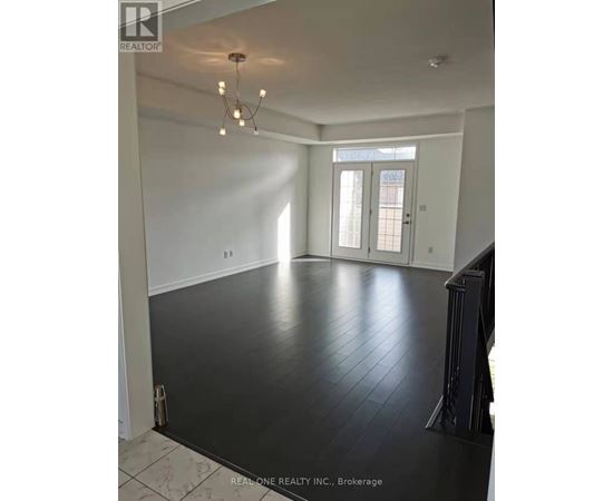 A spacious room with a chandelier and a view of a doorway.