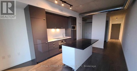 A modern kitchen with dark brown cabinets and a white island.