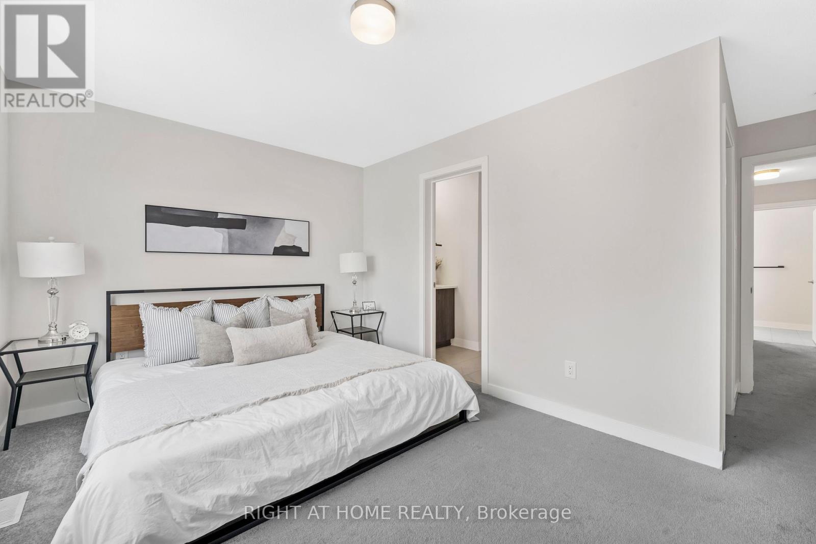 A bedroom with a large bed and a painting on the wall.