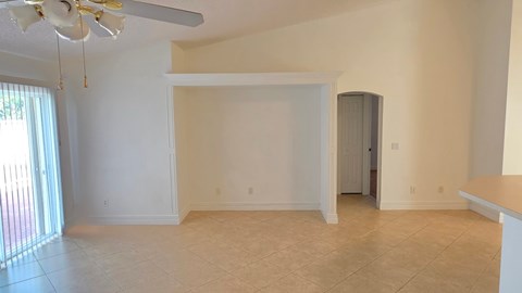A spacious room with a ceiling fan and tiled floor.