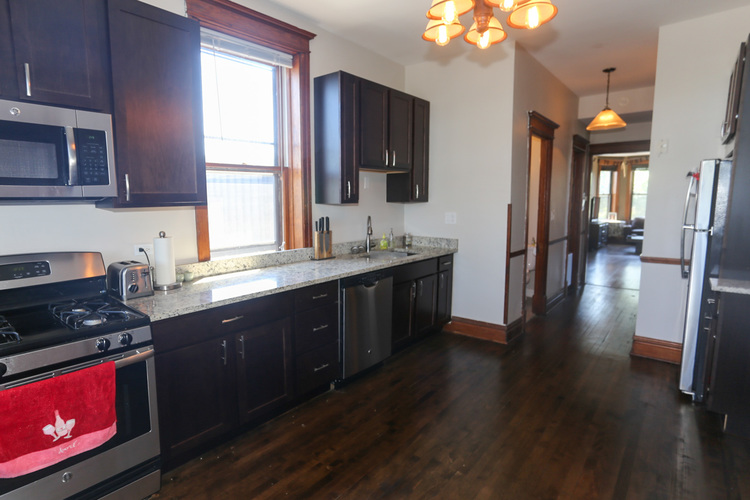 A kitchen with dark wood cabinets and a stove top oven.