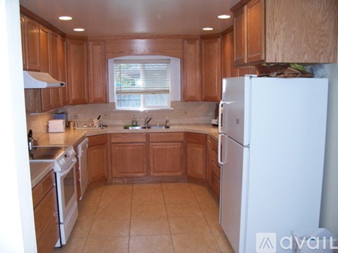 A kitchen with wooden cabinets and a white refrigerator.