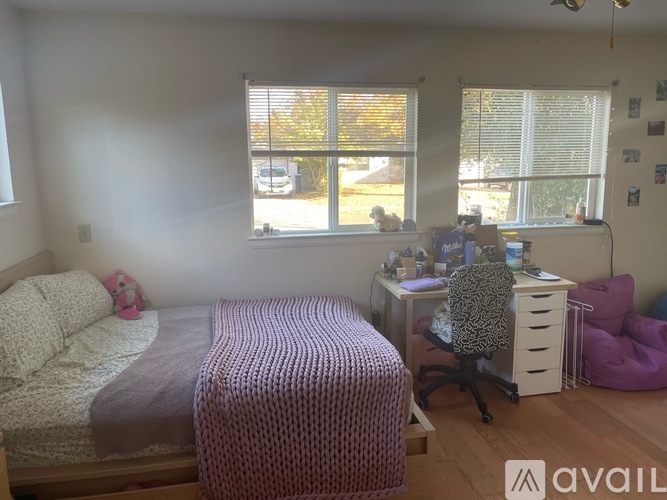 A bedroom with a bed, desk, and chair.