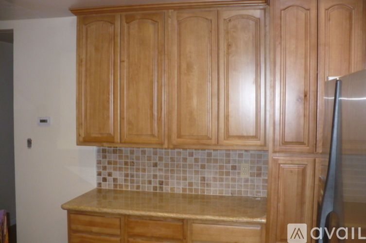 A kitchen with wooden cabinets and a tiled backsplash.