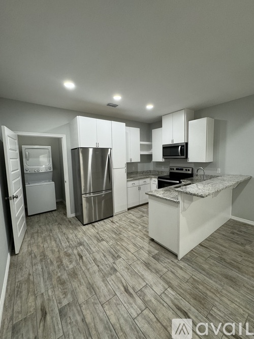 A kitchen with a refrigerator, microwave, and oven.