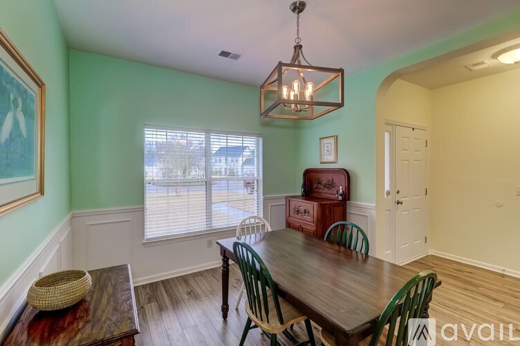 A dining room with a wooden table and chairs.