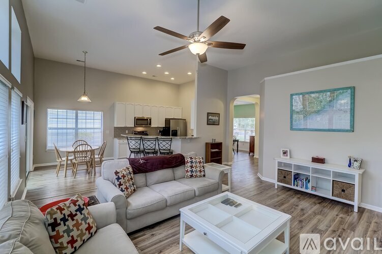 A living room with a white couch and a ceiling fan.
