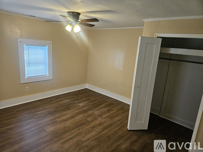A room with a ceiling fan and a window.