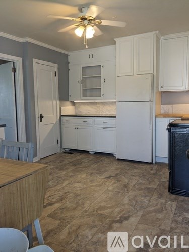 A kitchen with white cabinets and a wooden table.