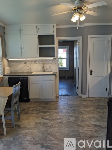 A kitchen with a marble countertop and a ceiling fan.