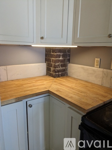A kitchen with a wooden countertop and white cabinets.