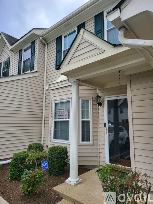 A house with a front porch and a sign that says "For Sale".