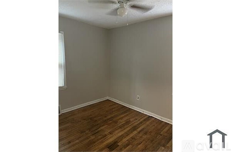 A room with wooden flooring and a ceiling fan.
