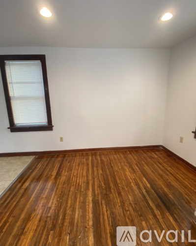 A room with wooden flooring and a window.