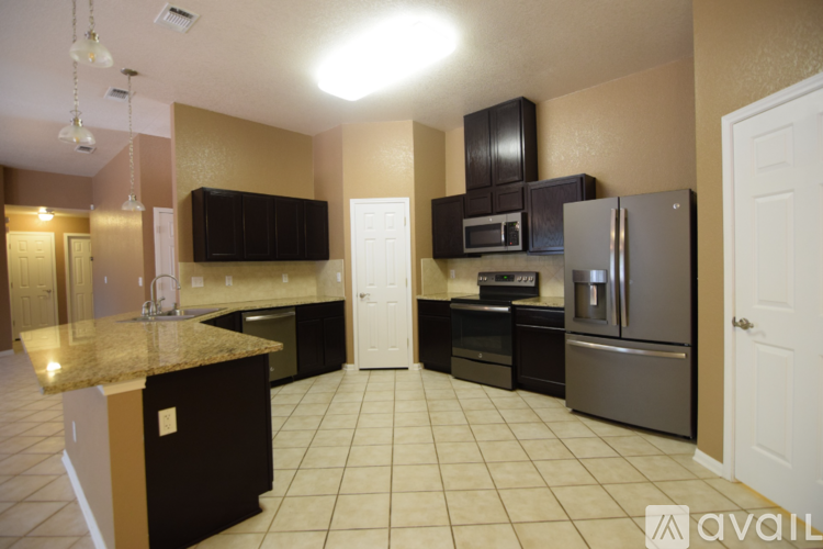A kitchen with brown cabinets and a granite counter top.