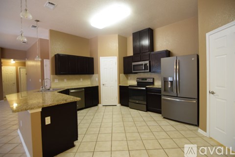 A kitchen with brown cabinets and a granite counter top.