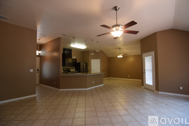 A spacious room with a ceiling fan and tiled flooring.