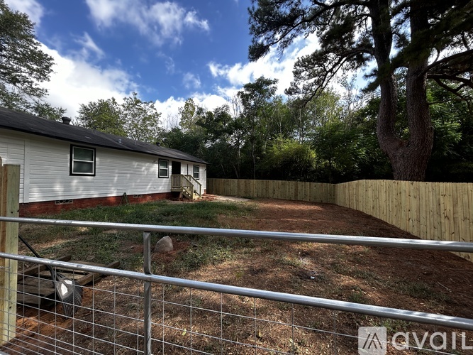 A backyard with a fence and a tree.