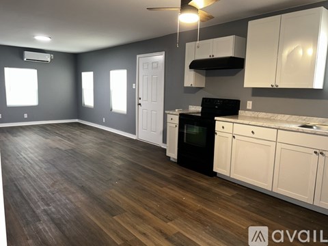 A kitchen with a black oven and white cabinets.