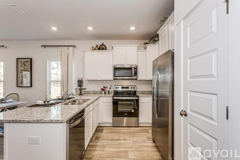 A kitchen with white cabinets and stainless steel appliances.