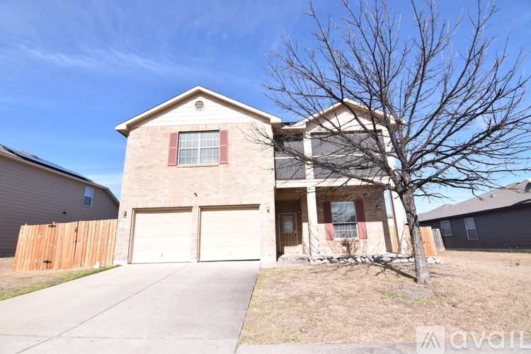 A house with a bare tree in front of it.