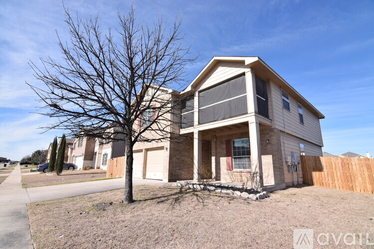 A house with a tree in front of it is for sale.