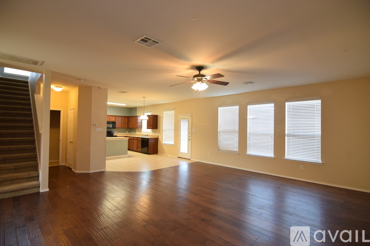 A spacious room with wooden floors and a ceiling fan.