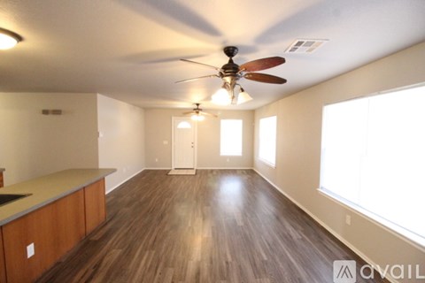 A room with wooden floors and a ceiling fan.