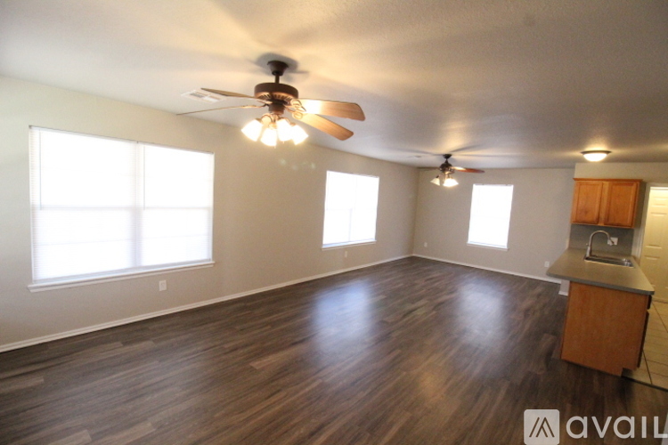 A room with wooden floors and a ceiling fan.