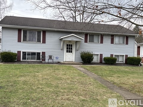 A house with a grey siding and a white door.