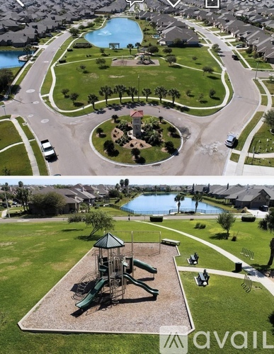 A playground with a green slide and a play structure in the middle of a grassy area.