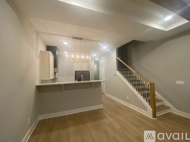 A spacious room with a staircase and a counter.