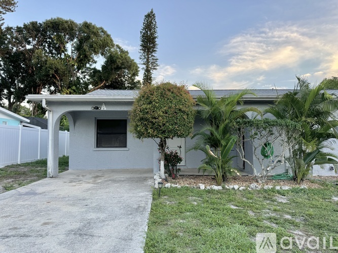 A house with a grey roof and a white fence.