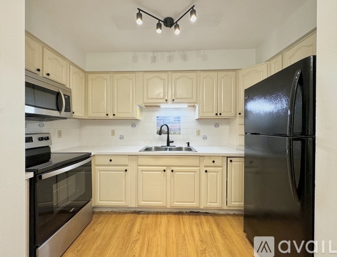 A kitchen with wooden cabinets and black appliances.