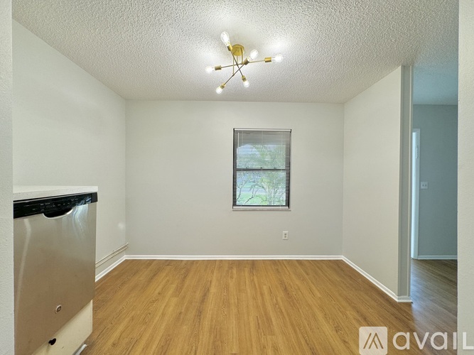A room with a window and a fridge.
