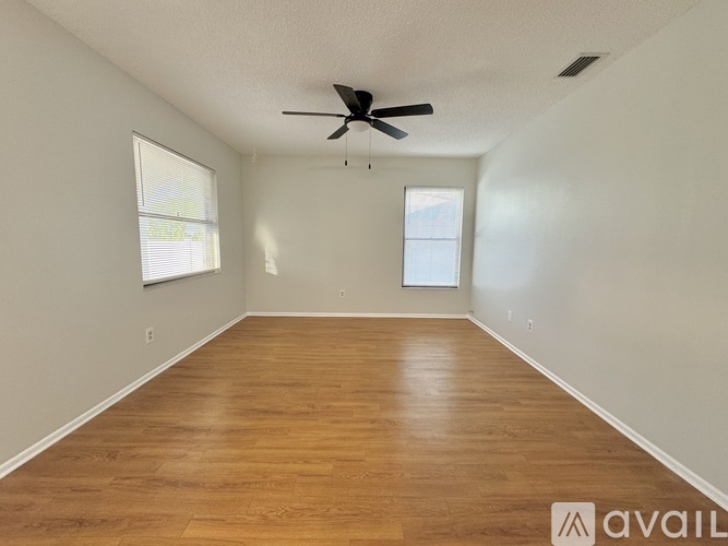 A room with wooden flooring and a ceiling fan.