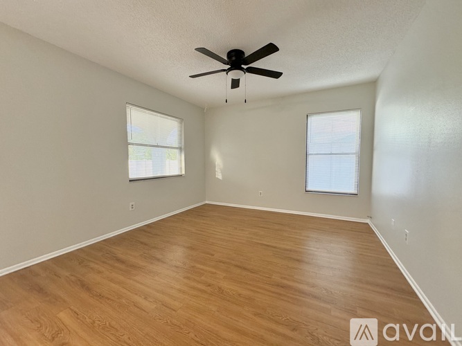 A room with wooden flooring and a ceiling fan.