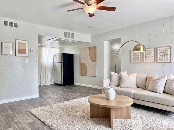 A living room with a white couch and a wooden coffee table.