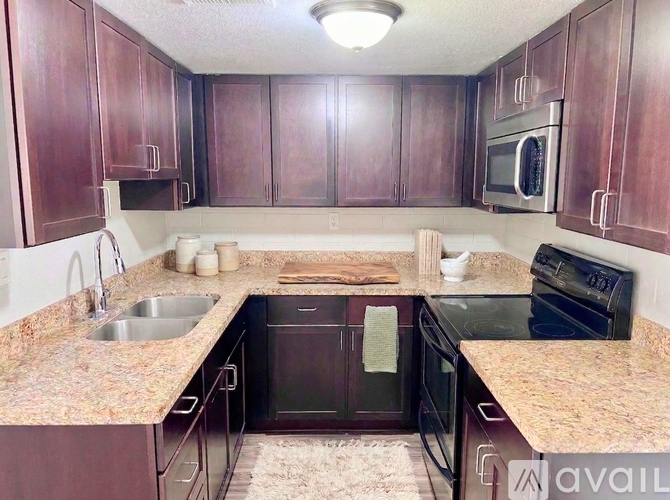 A kitchen with brown cabinets and a granite countertop.