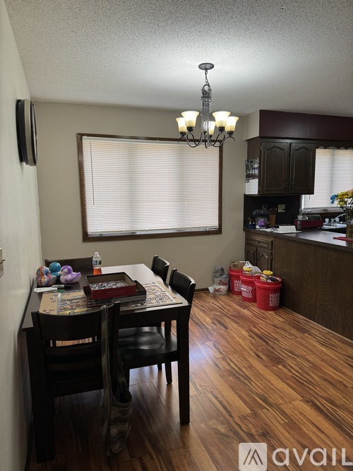 A dining room with a wooden table and chairs.