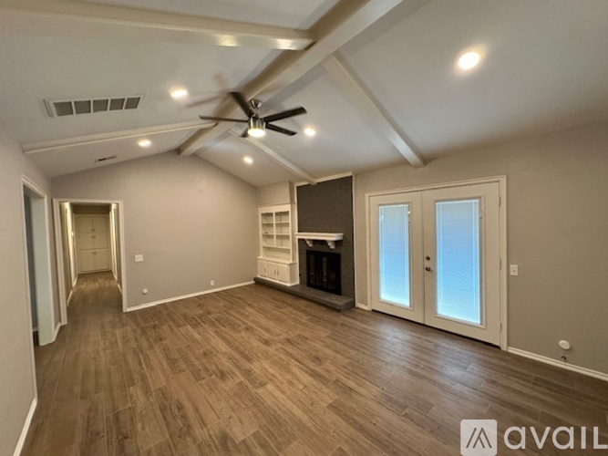 A spacious room with a ceiling fan and lighting fixtures.