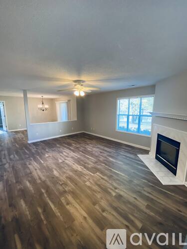 A room with a fireplace and wooden flooring.
