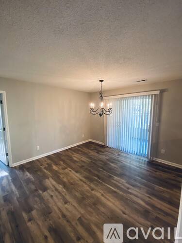 A room with wooden flooring and a chandelier.