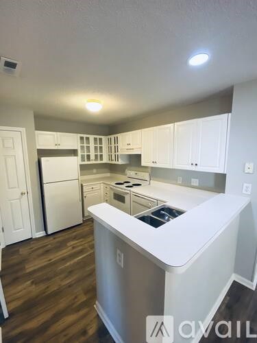 A kitchen with white cabinets and a white island.