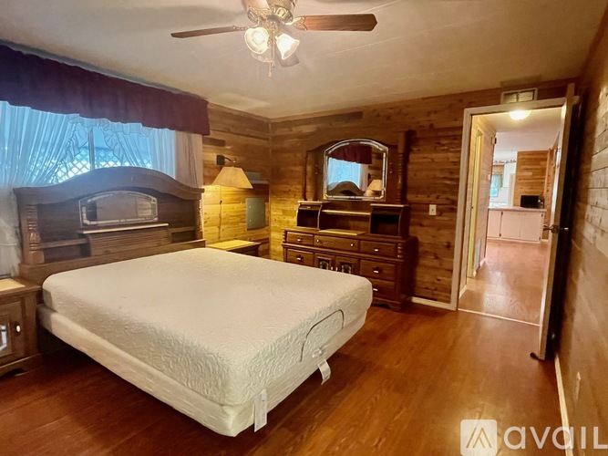 A bedroom with a bed, dresser, and mirror.