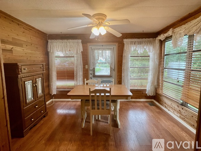 A wooden dining room with a table and chairs.