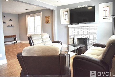 Two leather chairs with cushions are in front of a fireplace in a living room.
