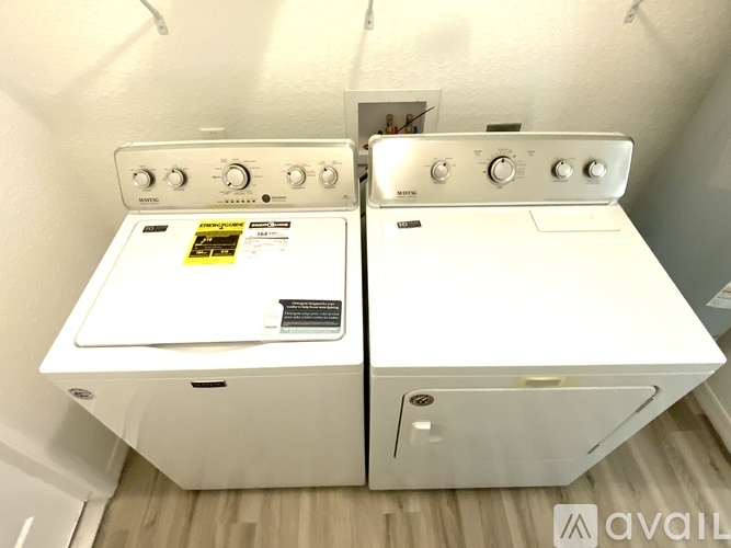Two white ovens with control knobs and a sticker on the left one.