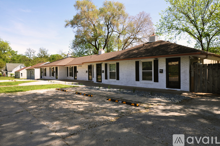 A white building with a brown roof is available for rent.